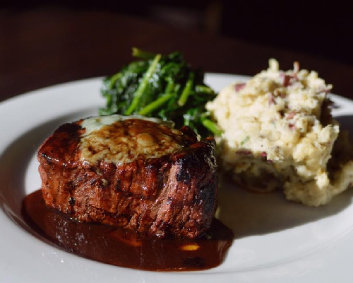 a steak with mashed potatoes and green beans on a plate from Copper Canyon Grill